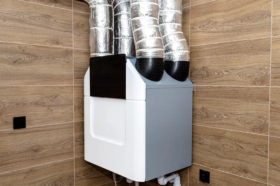 A mechanical heat recover ventilator inside someone's home, displaying the four iconic vents that push stale air out and bring fresh air in.