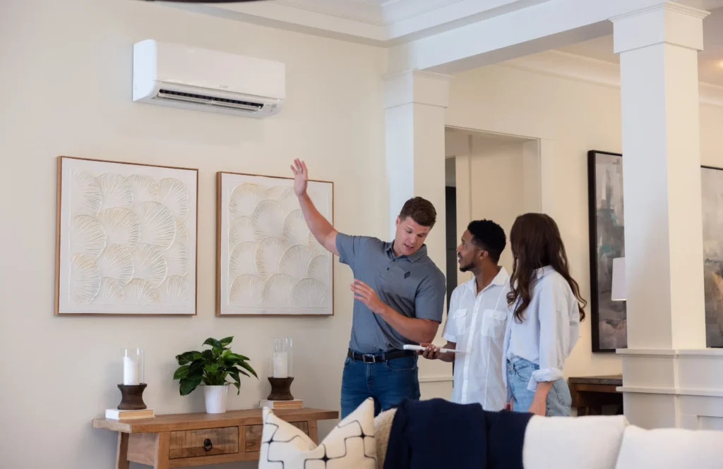 HVAC estimator showing couple how to operating their ductless mini split in their home.